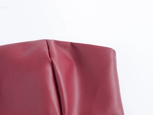 Gros plan de la texture du similicuir rouge avec grain visible sur le pantalon