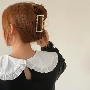 Elegant gold metal hair claw clip with white pearls for women in stylish half-up hairstyles