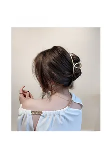 Elegant gold metal flower hair claw clip with matte finish on female model hairstyle