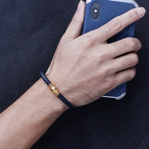 Men's blue braided leather bracelet with golden magnetic clasp shown on wrist