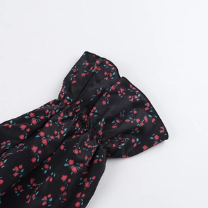 Dettaglio dei polsini elastici con ruches e stampa floreale su abito in chiffon
