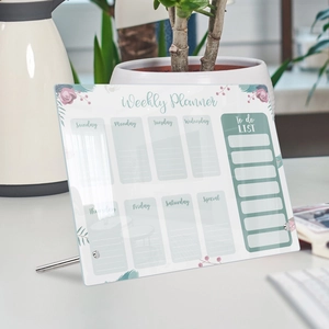 Detailed view of an acrylic weekly planner on a desk with floral patterns and metal stands