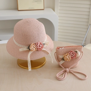 Detail of pink straw sun hat and matching bag set with lace ribbons and 3D floral accents