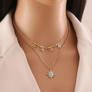 Double-layer gold necklace with tree of life charm and sun turquoise pendant on a model