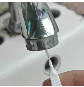 Detail of a thin gap cleaning brush scrubbing shower head nozzles and faucet holes