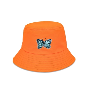 Détail du chapeau bob orange avec broderie de papillon bleu et bord surpiqué de qualité