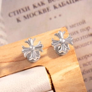 Sleek silver stainless steel cross stud earrings on a rustic wooden display stand