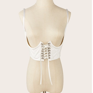 Détails d'un corset sous-poitrine blanc avec œillets métalliques argentés et laçage