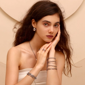 Silver jewelry set featuring minimalist earrings, necklaces and rings on model