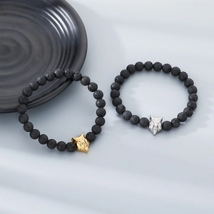 Macro detail of 8mm lava rock bead bracelets featuring gold and silver wolf head accents