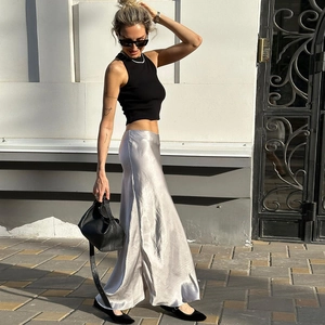 Vista street style di una gonna midi in raso argento con trama setosa e un elegante drappeggio