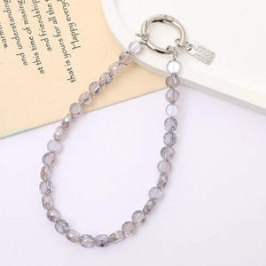 Macro shot of purple crystal faceted beads with silver Hand Made charm and metal ring