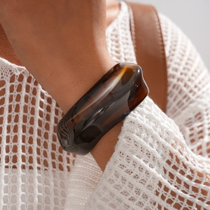 Close-up of a wide brown marble resin bangle with a vintage tortoiseshell texture