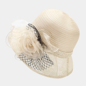 Detailed texture of beige organza flower and delicate lace on women's sun hat