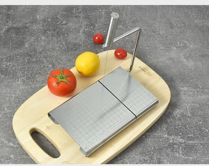 Macro detail of stainless steel cheese slicer with precise scale on a wooden board