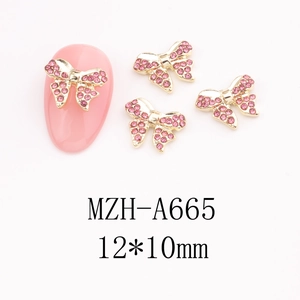 Detailed view of pink rhinestone bow nail art charms with gold alloy base and 12x10mm size