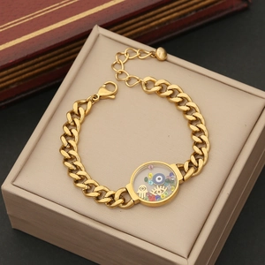 Detail of gold Cuban chain bracelet with Evil Eye and Hamsa hand in a jewelry box
