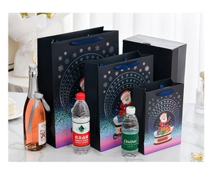 Three sizes of dark blue Christmas gift bags with ribbon handles and Santa prints