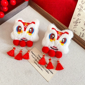 Detail of festive dancing lion hair clips with plush texture and red silk tassels