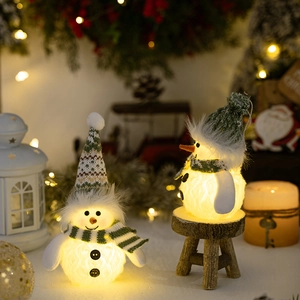 Glow-in-the-dark Christmas snowman statues with cozy green and white knitted hats