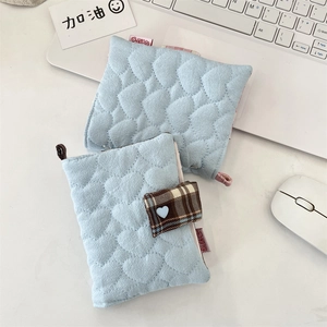 Gros plan de protège-cahiers en tissu matelassé bleu clair avec de jolis motifs de cœurs