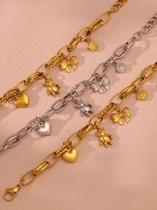 Detailed close-up of bow and heart charms on a gold-plated stainless steel chain
