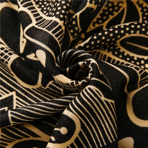 Macro shot of fabric texture showing abstract beige geometric patterns on a black scarf