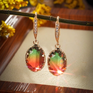 Detail of oval gradient gemstone earrings with gold plating and cubic zirconia accents