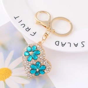 Macro shot of heart keychain with blue crystal flowers and white rhinestones