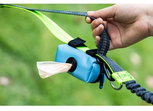 Close-up of reflective nylon dog leash with attached blue waste bag dispenser for pet waste
