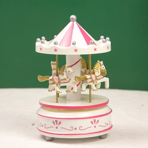 Pink and white carousel music box featuring golden pillars and unicorn details on a pedestal