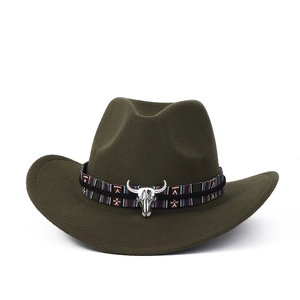 Détail d'un chapeau de cowboy en feutre vert olive avec ruban ethnique et boucle tête de taureau