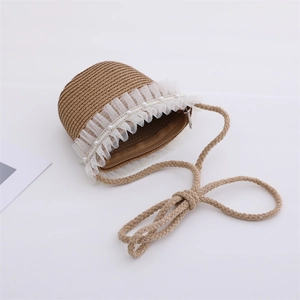 Close-up of woven straw handbag with white lace trim and imitation pearl accents