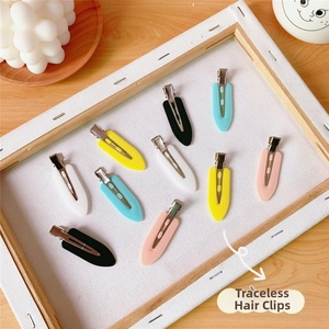 Detailed macro view of 10 seamless matte colorful duckbill hair clips set in a wood frame