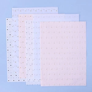 Detailed view of pink and white tissue paper with gold star and polka dot patterns