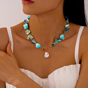 Dettaglio della collana stile oceano con perline blu, perla barocca e chiusura a T oro