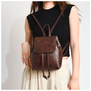 Detail view of vintage brown PU leather backpack with drawstring and flap closure