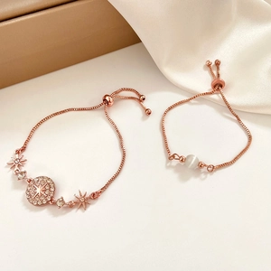 Close-up of rose gold adjustable bracelets with starburst charms and white beads