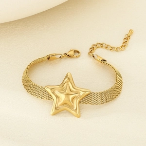 Detailed macro of golden mesh strap bracelet with a central star charm and lobster clasp