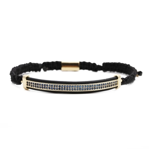Adjustable black woven rope bracelet with gold bar and sparkling blue zircon inlay