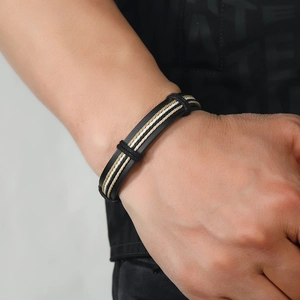 Men's multi-layer woven bracelet with black leather band and beige braided rope on wrist