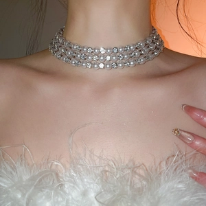 Close-up of triple-layered pearl and rhinestone choker necklace on a model's neck