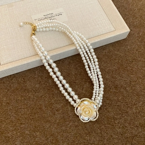 Elegant multi-layer pearl necklace featuring a large vintage rhinestone flower pendant