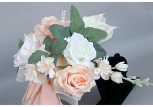 Close-up of bridal bouquet with white and orange silk roses, pearls and satin ribbons