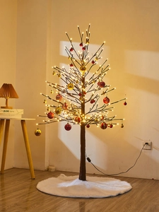 Illuminated Christmas tree with LED lights, festive ornaments, and white plush tree skirt