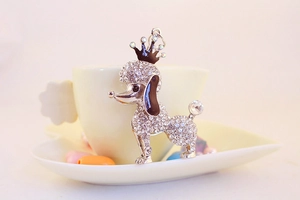 Close-up of a silver poodle keychain with sparkling rhinestones and black enamel crown