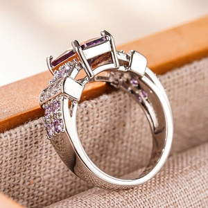 Macro detail of silver square cut purple gemstone ring with side pave setting