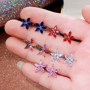 Detailed close-up of colorful five-petal flower stud earrings with marquis-cut zircons