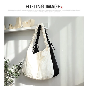 Detail of minimalist cream and black nylon shoulder bags with ruched scrunchie-style straps