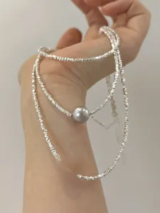 Detail of silver S925 necklaces featuring grey and white pearls on irregular silver beads